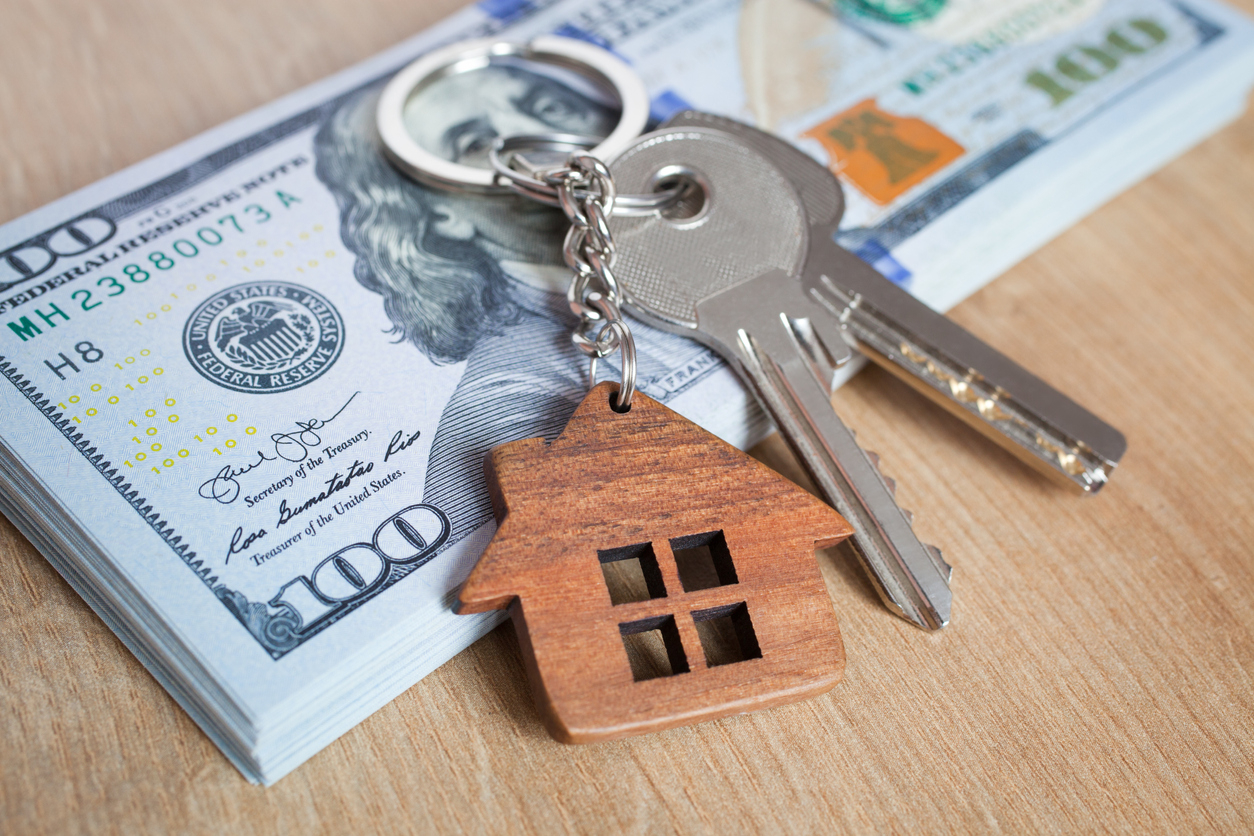 Des clés d'un bien immobilier sur une liasse de billets