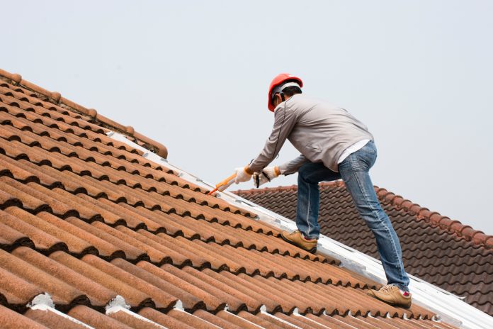 homme chantier sur toit en tuile rénovation